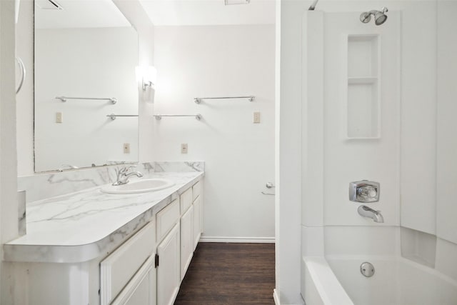 full bathroom featuring baseboards, tub / shower combination, wood finished floors, and vanity