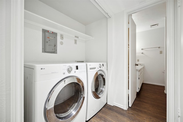 laundry room featuring dark wood-type flooring, washing machine and clothes dryer, and electric panel