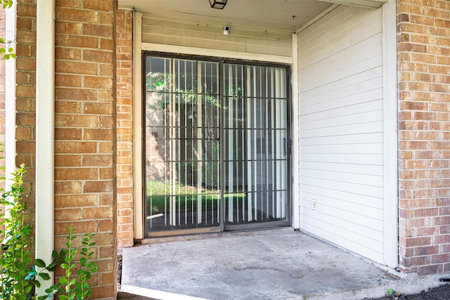 property entrance featuring brick siding