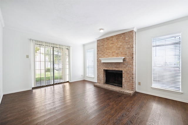 unfurnished living room featuring brick wall, a fireplace, ornamental molding, and dark hardwood / wood-style floors