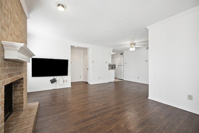 unfurnished living room with dark wood-style floors, a brick fireplace, a ceiling fan, and crown molding