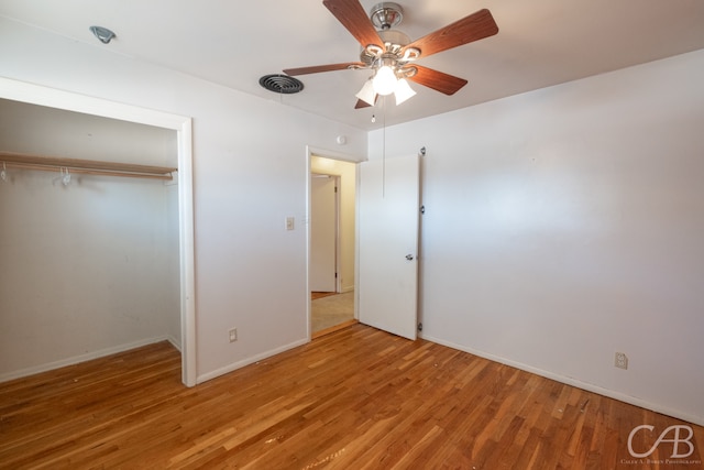 unfurnished bedroom with ceiling fan, hardwood / wood-style floors, and a closet