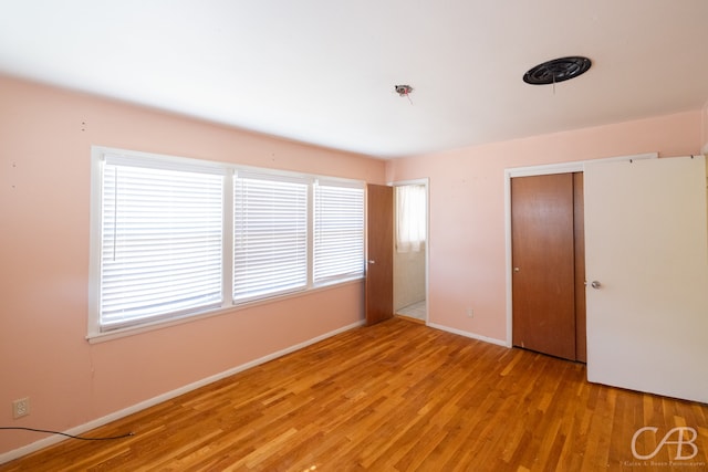 unfurnished bedroom featuring light wood-type flooring and a closet