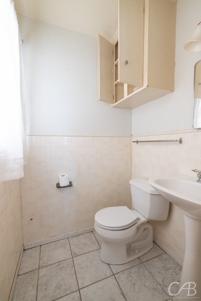 bathroom with tile walls, toilet, and tile patterned floors