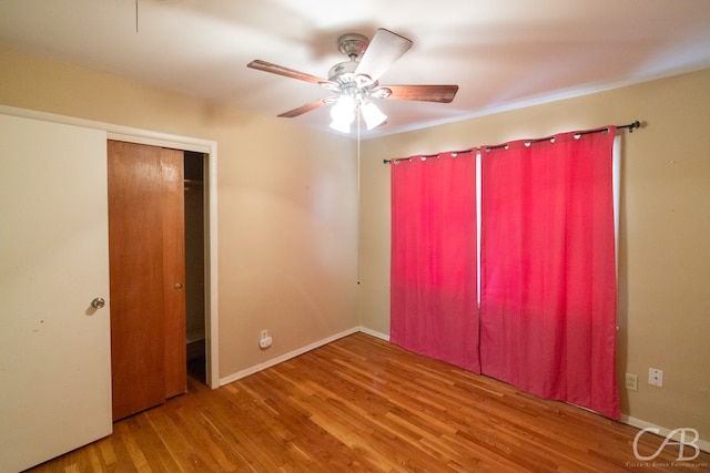 unfurnished bedroom featuring ceiling fan, wood-type flooring, and a closet