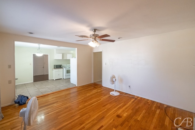 unfurnished living room with ceiling fan and light hardwood / wood-style floors