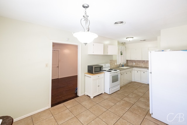 kitchen featuring tasteful backsplash, white appliances, pendant lighting, white cabinetry, and light tile patterned floors