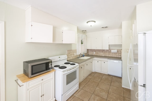 kitchen featuring white appliances, white cabinets, light tile patterned floors, and backsplash