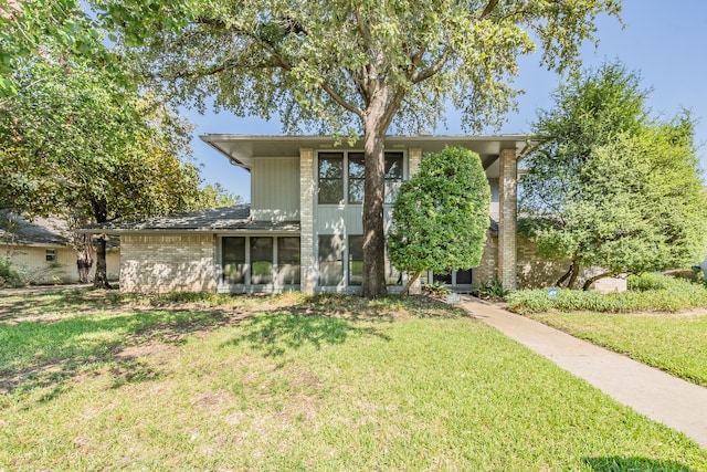 view of front of property with a front lawn and brick siding