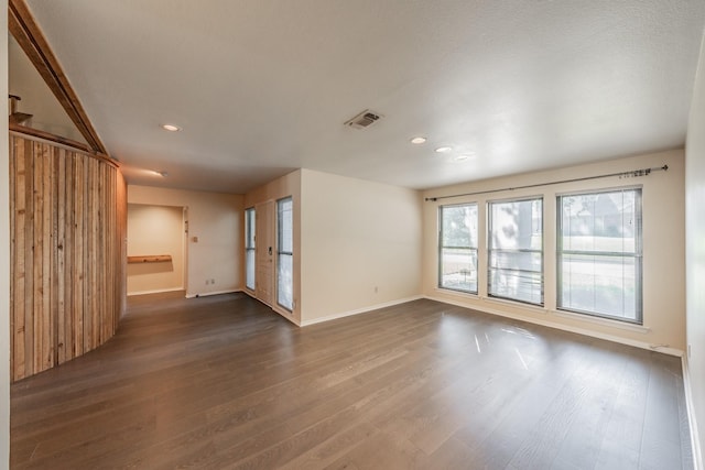 unfurnished room featuring baseboards, visible vents, dark wood-style flooring, and recessed lighting