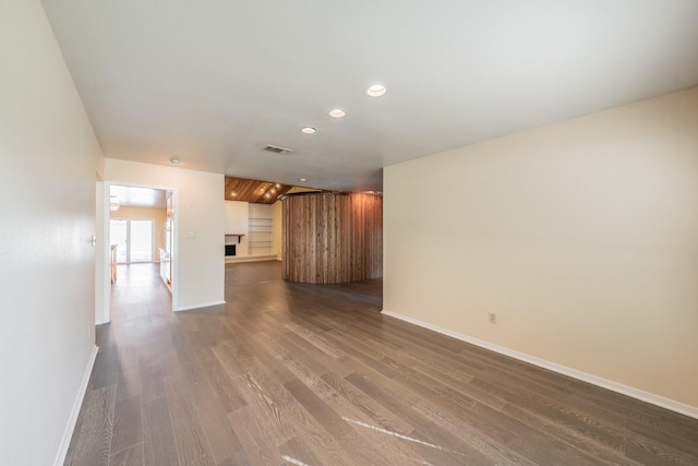 unfurnished living room featuring recessed lighting, dark wood-style flooring, a fireplace, visible vents, and baseboards