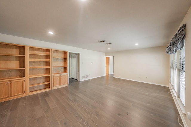 empty room with baseboards, visible vents, dark wood-type flooring, and recessed lighting