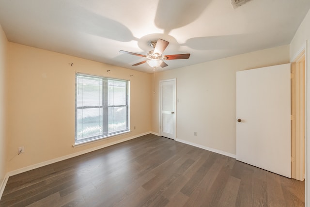 spare room featuring dark wood-type flooring and ceiling fan