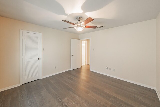 spare room featuring dark wood-type flooring and ceiling fan