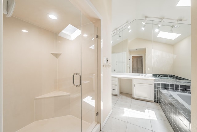 bathroom featuring lofted ceiling with skylight, a garden tub, tile patterned flooring, vanity, and a shower stall