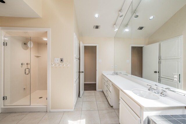 bathroom featuring vanity, a shower with shower door, vaulted ceiling, and tile patterned flooring