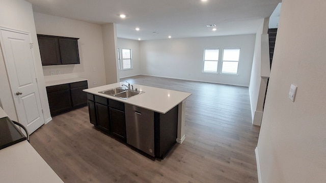 kitchen with dark brown cabinetry, a center island with sink, sink, and light hardwood / wood-style flooring