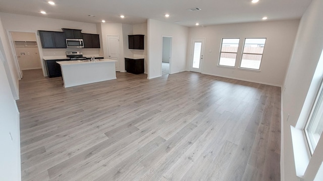 kitchen featuring light wood-type flooring, a kitchen island with sink, sink, and stainless steel appliances