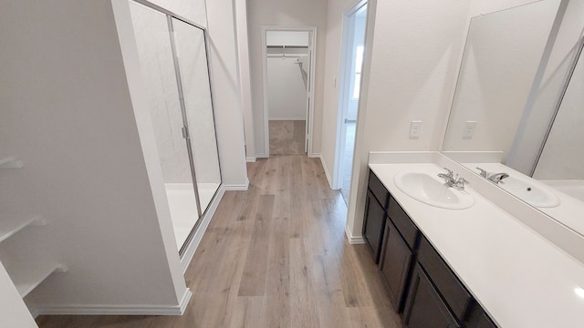 bathroom featuring walk in shower, wood-type flooring, and vanity