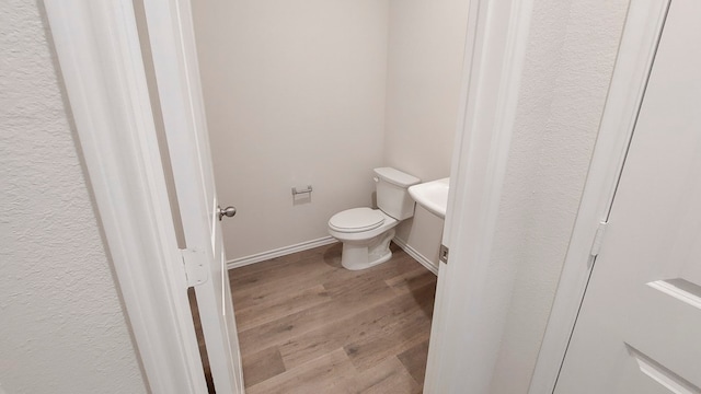 bathroom with hardwood / wood-style flooring and toilet