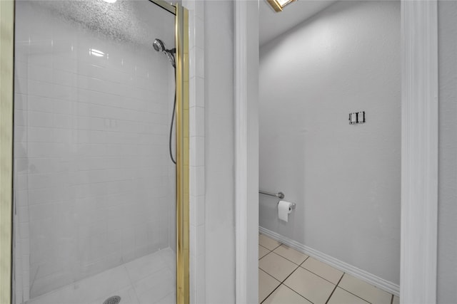 full bath with tile patterned flooring, baseboards, and a stall shower