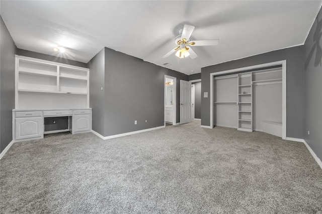 unfurnished bedroom with visible vents, a ceiling fan, baseboards, light colored carpet, and built in study area