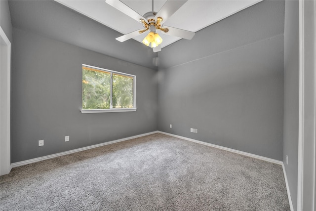 carpeted spare room featuring baseboards and ceiling fan