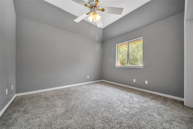 carpeted empty room with vaulted ceiling, baseboards, and ceiling fan