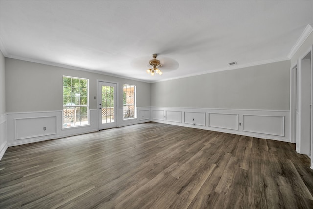 empty room with visible vents, dark wood finished floors, and crown molding