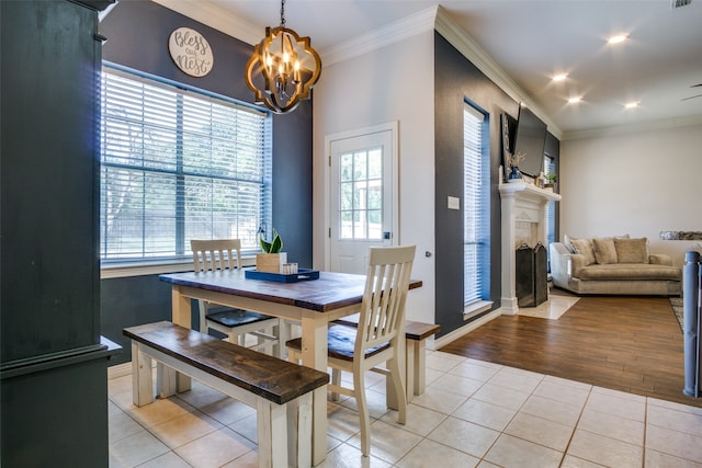 dining area with a chandelier, light tile patterned floors, plenty of natural light, and ornamental molding