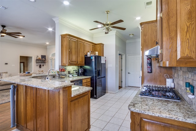 kitchen with black appliances, light stone countertops, range hood, tasteful backsplash, and kitchen peninsula