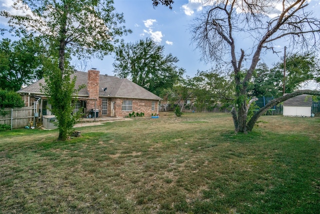 view of yard featuring a patio area, a jacuzzi, and a storage unit