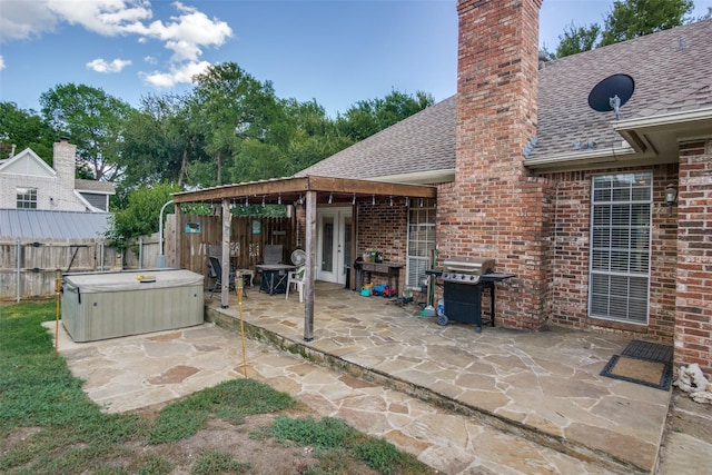 view of patio / terrace featuring a hot tub and a grill