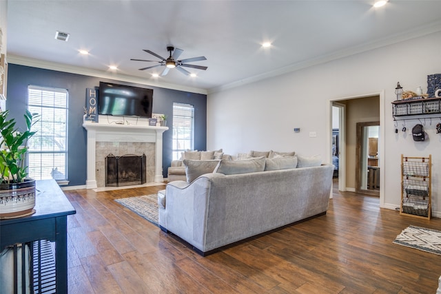 living room featuring dark hardwood / wood-style floors, crown molding, and a fireplace