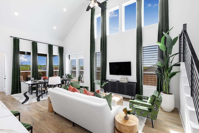 living area featuring high vaulted ceiling, light wood finished floors, and recessed lighting