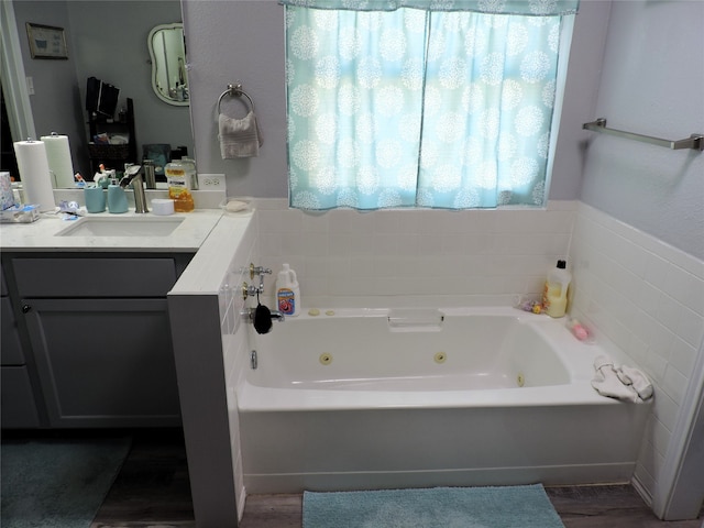 bathroom with hardwood / wood-style floors, vanity, and a bath