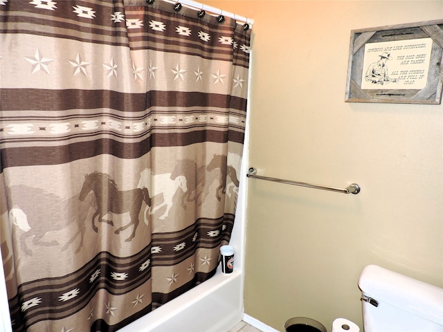 bathroom featuring shower / bathtub combination with curtain and toilet