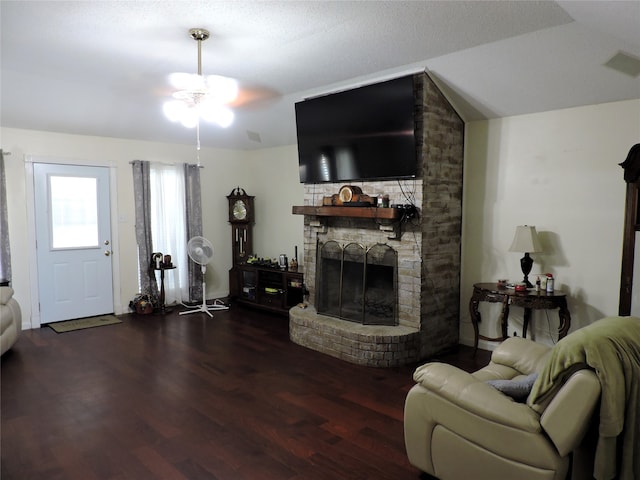 living room with hardwood / wood-style floors, brick wall, a brick fireplace, and ceiling fan