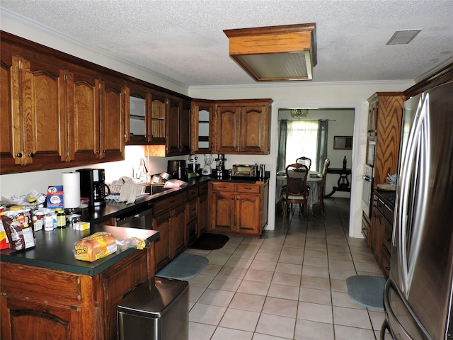 kitchen with a textured ceiling, crown molding, appliances with stainless steel finishes, light tile patterned floors, and sink