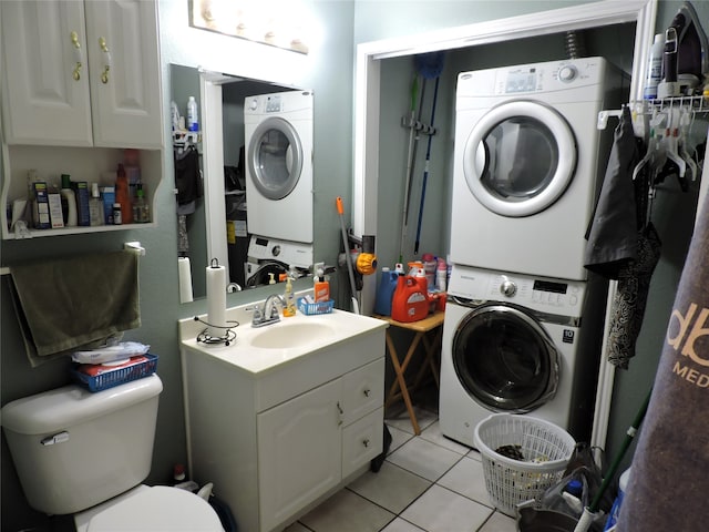 clothes washing area with light tile patterned flooring, sink, and stacked washing maching and dryer