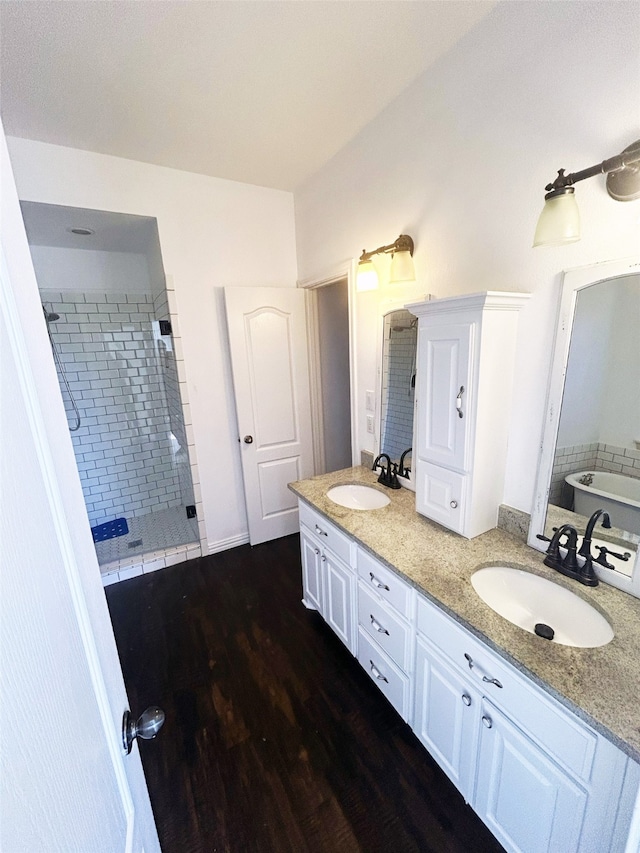 bathroom featuring a tile shower, vanity, and wood-type flooring