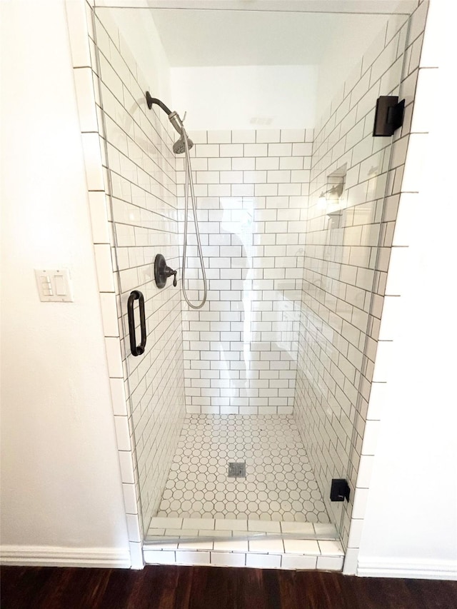 bathroom featuring a stall shower and baseboards