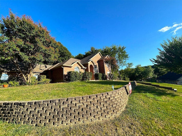 view of front of home featuring brick siding and a front yard