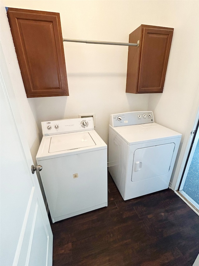 clothes washing area featuring cabinets, separate washer and dryer, and dark hardwood / wood-style flooring