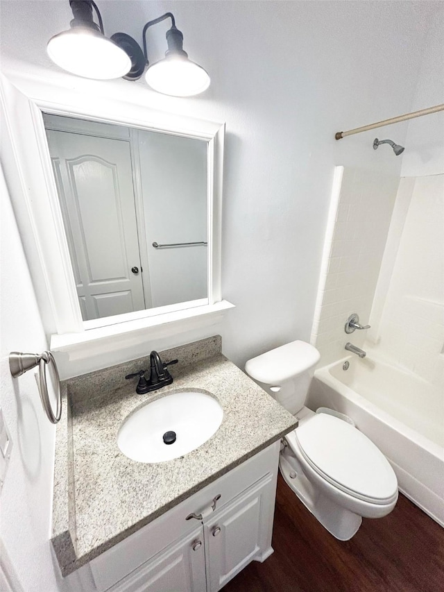 bathroom featuring toilet, shower / washtub combination, wood finished floors, and vanity