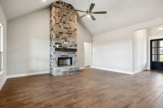 unfurnished living room featuring high vaulted ceiling, a fireplace, and ceiling fan with notable chandelier