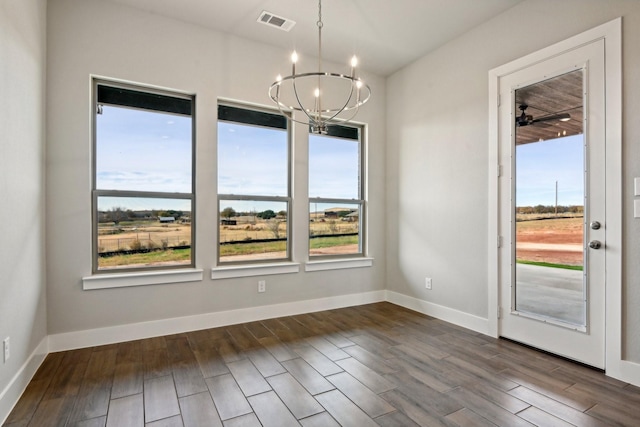 unfurnished dining area with ceiling fan with notable chandelier