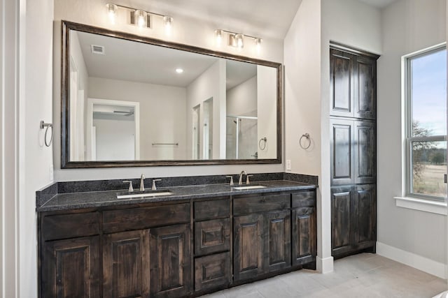 bathroom with a shower with shower door, tile patterned floors, and vanity