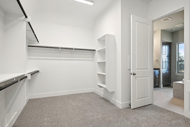 walk in closet featuring light carpet