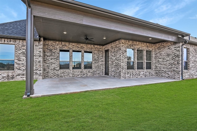 rear view of house with a patio area, a yard, and ceiling fan